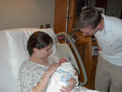 Mom and Dad getting their first peek at the cleaned and swaddled boy